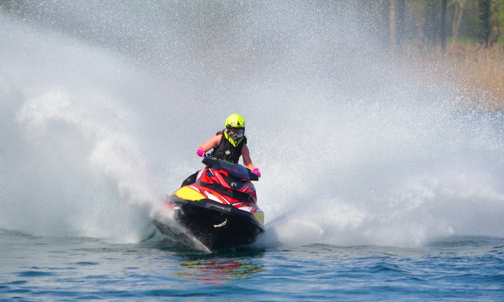 Man in Helmet riding jet ski with splash