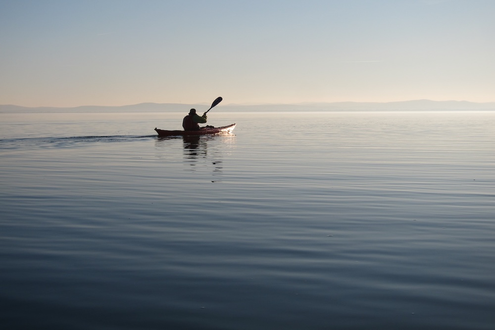 Silhouette man on Kayak at Sunset