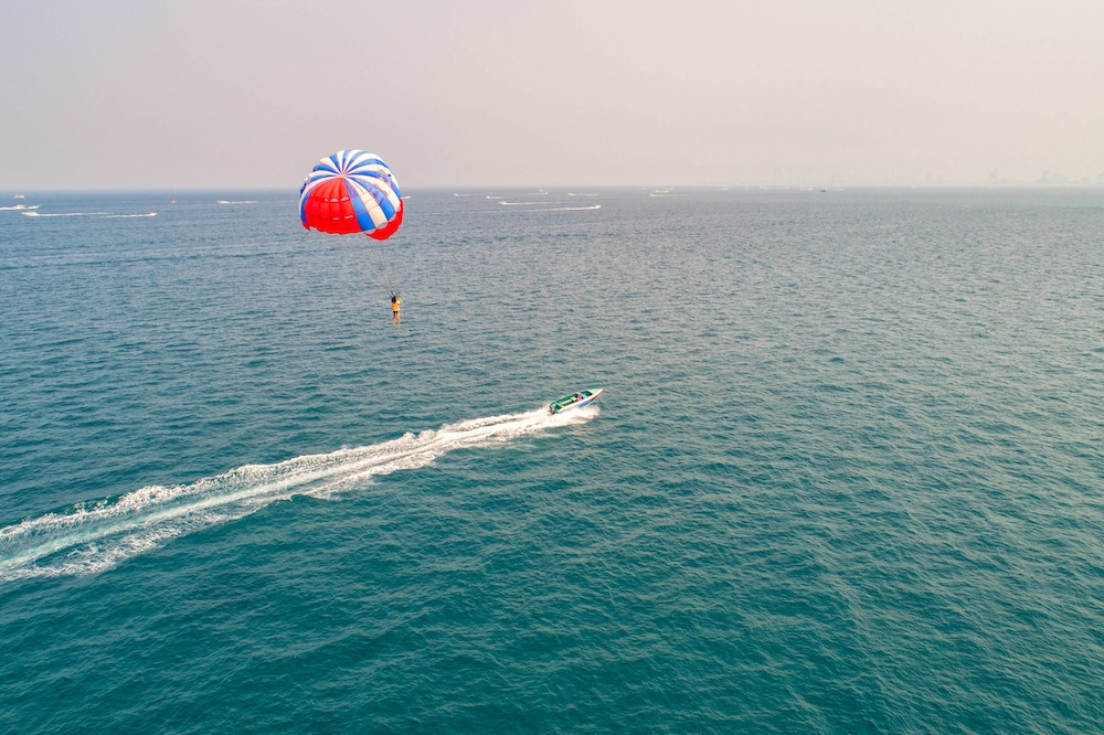 Parasailing over the ocean with Small vessel